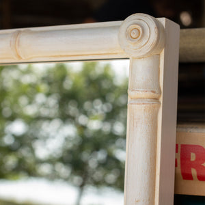 The roundel corner detail on a whitewashed bamboo mirror. 